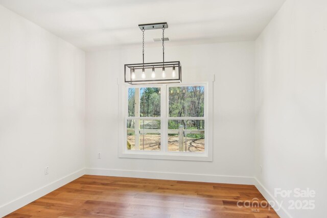 40 Haywood Park Dr, Hendersonville, NC 28791 - unfurnished dining area with baseboards, wood finished floors, and a chandelier