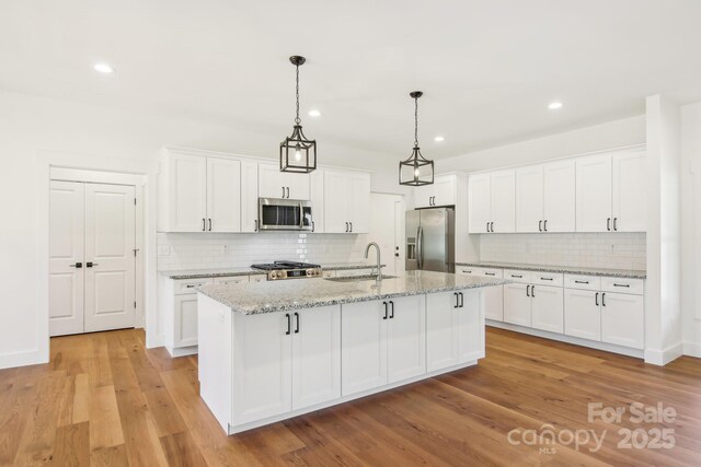 40 Haywood Park Dr, Hendersonville, NC 28791 - kitchen with appliances with stainless steel finishes, a sink, backsplash, recessed lighting, and white cabinetry