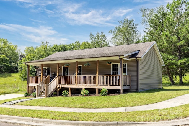 view of front of house with a porch, ceiling fan, and a front lawn