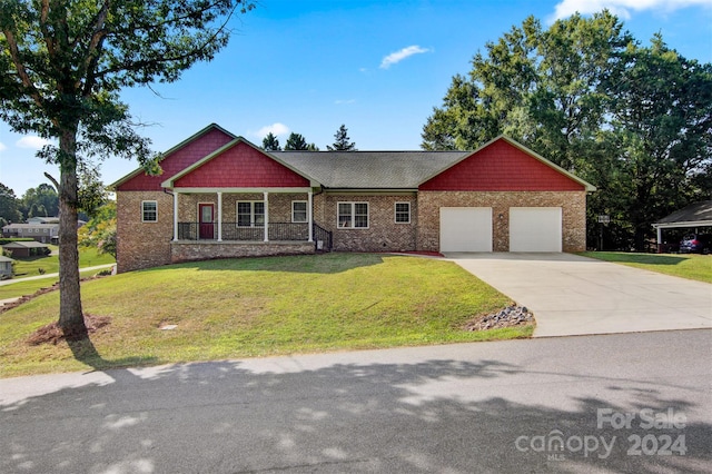 view of front of property featuring covered porch, a front yard, and a garage