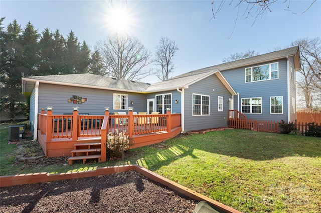 rear view of house featuring a yard, central AC unit, and a wooden deck