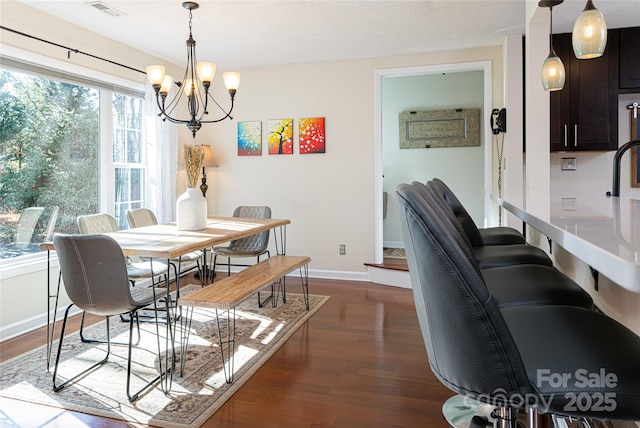 dining area featuring dark hardwood / wood-style flooring and a chandelier