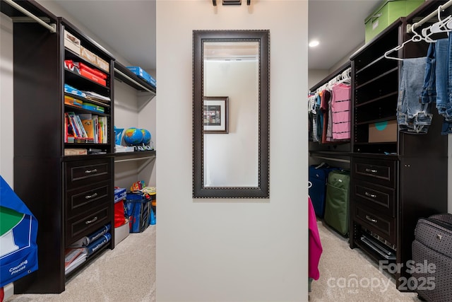 walk in closet featuring light carpet