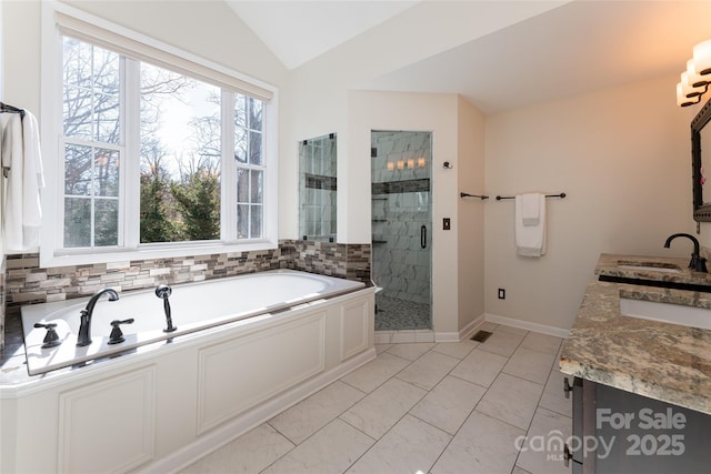 bathroom with tile patterned flooring, vanity, separate shower and tub, and vaulted ceiling