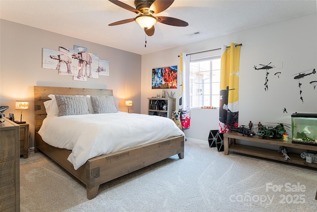 carpeted bedroom with a textured ceiling and ceiling fan