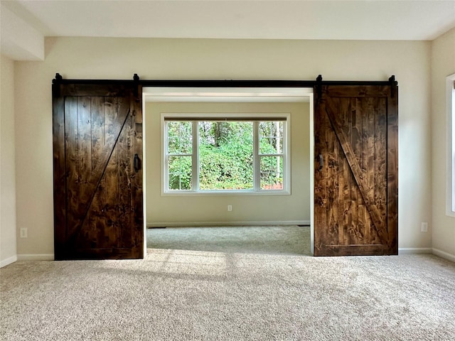 carpeted spare room with a barn door