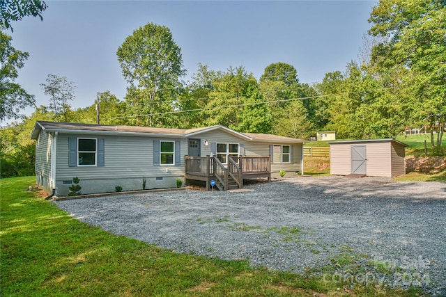 back of property featuring a lawn, a wooden deck, and a storage unit