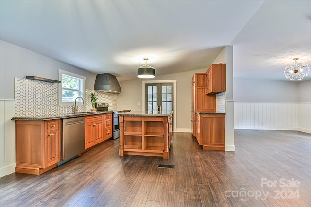 kitchen featuring a center island, decorative light fixtures, appliances with stainless steel finishes, custom exhaust hood, and dark hardwood / wood-style flooring