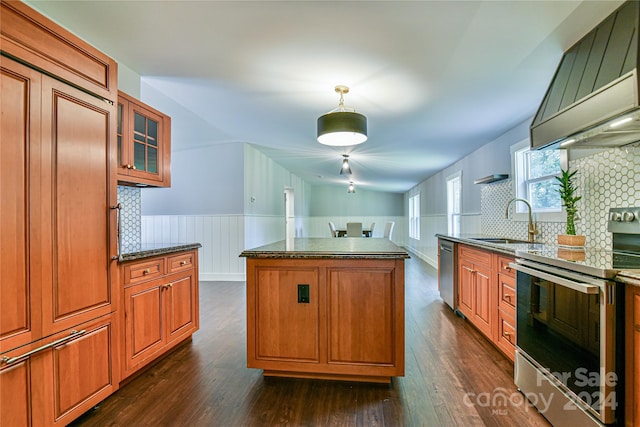 kitchen featuring a center island, stainless steel appliances, hanging light fixtures, and dark wood-type flooring