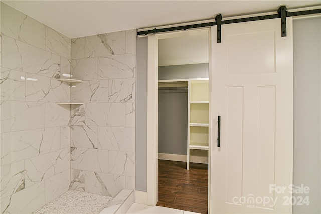 bathroom with hardwood / wood-style flooring and tiled shower