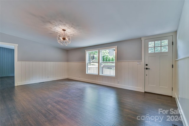 entryway with plenty of natural light, dark hardwood / wood-style floors, and a notable chandelier