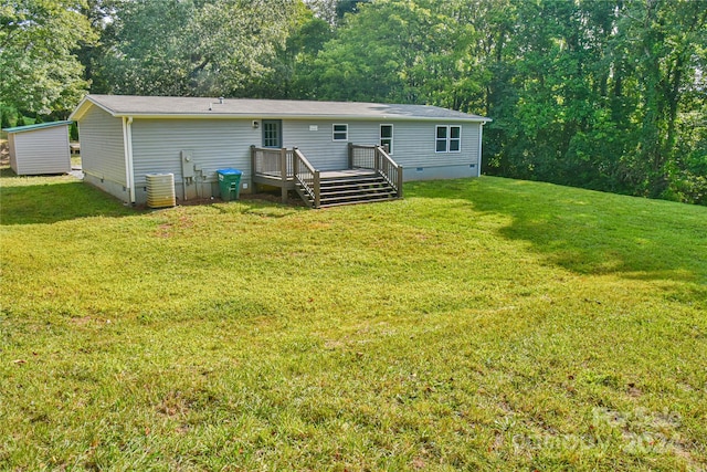 rear view of property with a yard and a deck