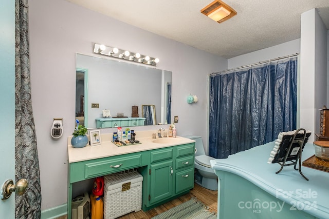 bathroom featuring toilet, hardwood / wood-style floors, vanity, and a textured ceiling