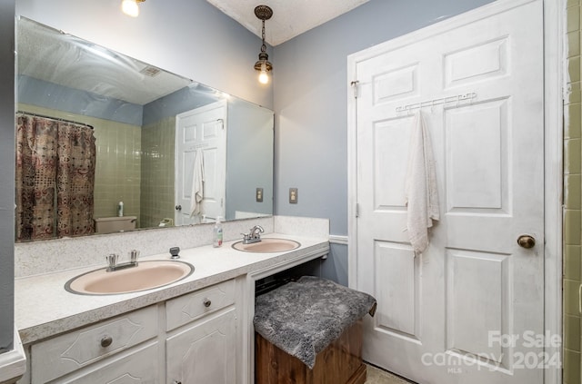 bathroom featuring vanity, a textured ceiling, and toilet