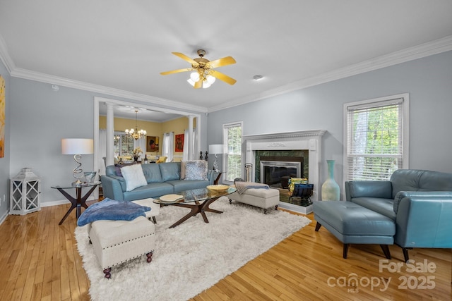 living room with wood-type flooring, crown molding, and a high end fireplace