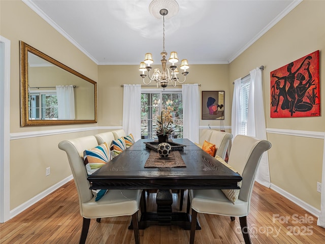 dining room with ornamental molding, a chandelier, and hardwood / wood-style floors