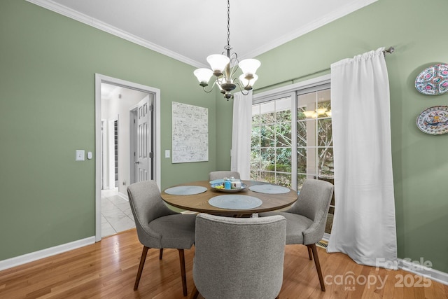 dining area with a chandelier, light hardwood / wood-style floors, and ornamental molding