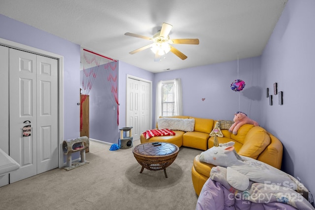 living room with ceiling fan and carpet