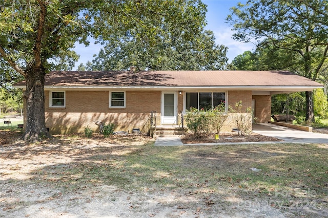 ranch-style house featuring a front lawn and a carport