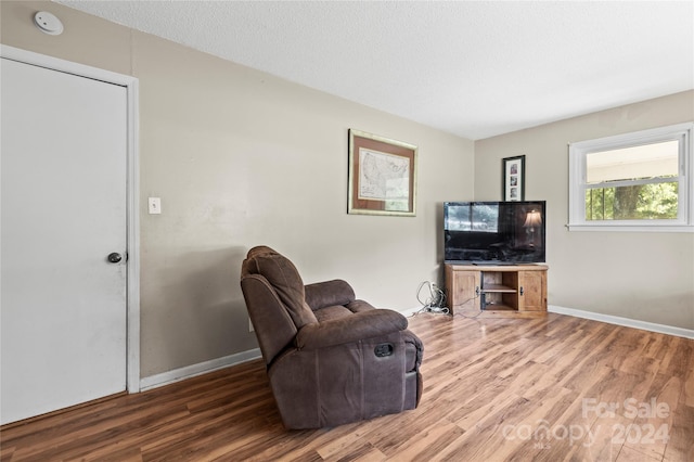 sitting room featuring a textured ceiling and wood-type flooring