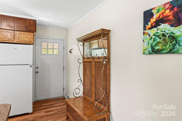 doorway to outside featuring dark hardwood / wood-style flooring, crown molding, and a textured ceiling