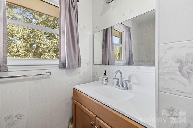 bathroom with tile walls, plenty of natural light, and vanity