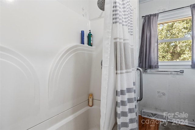 bathroom with tile walls and shower / bath combination with curtain