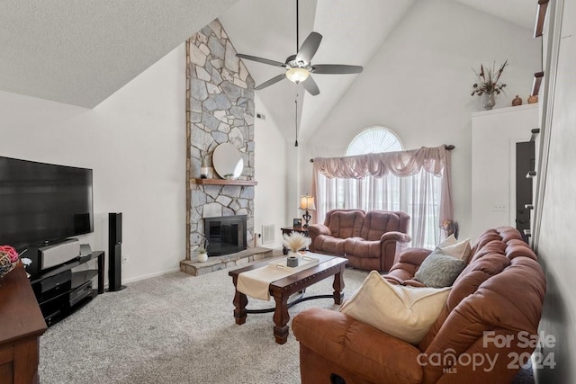 living room featuring a textured ceiling, a fireplace, carpet floors, high vaulted ceiling, and ceiling fan