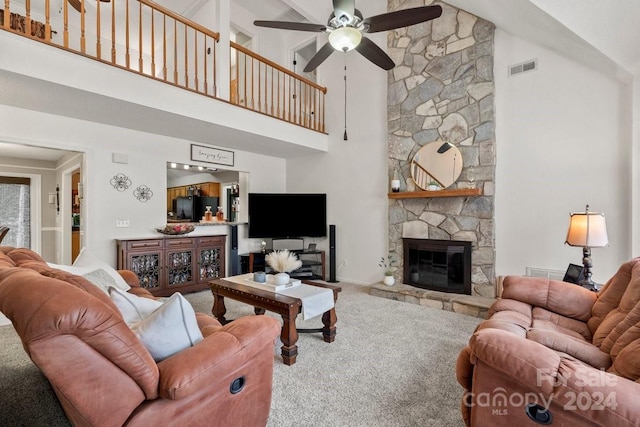 living room with carpet flooring, ceiling fan, high vaulted ceiling, and a stone fireplace