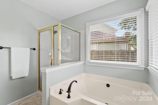 bathroom with a textured ceiling and separate shower and tub