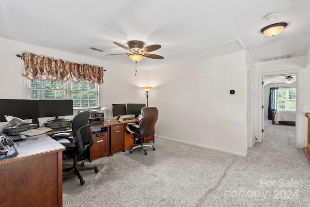 carpeted office space featuring a textured ceiling and ceiling fan