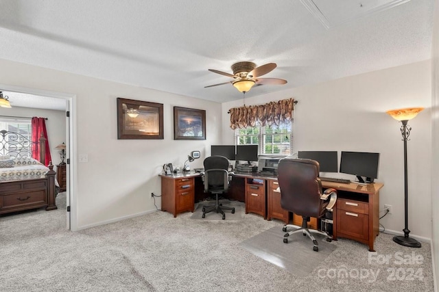 office space featuring a textured ceiling, light colored carpet, and ceiling fan