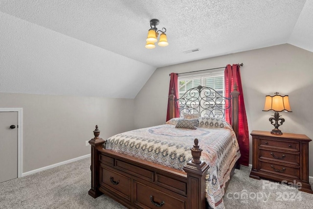 bedroom with light carpet, vaulted ceiling, and a textured ceiling