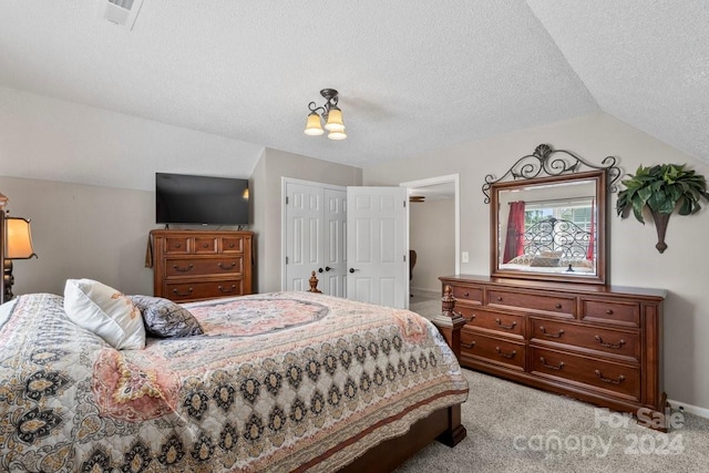 bedroom with lofted ceiling, light colored carpet, and a textured ceiling