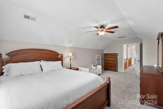 carpeted bedroom featuring ceiling fan, a textured ceiling, and vaulted ceiling