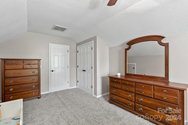 bedroom with lofted ceiling, ceiling fan, light carpet, and a textured ceiling