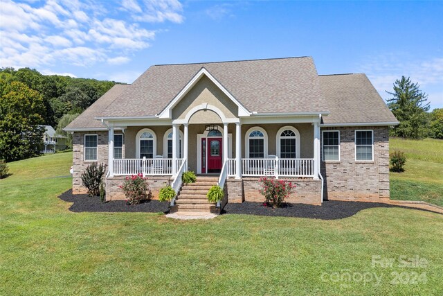 ranch-style house featuring a porch and a front lawn