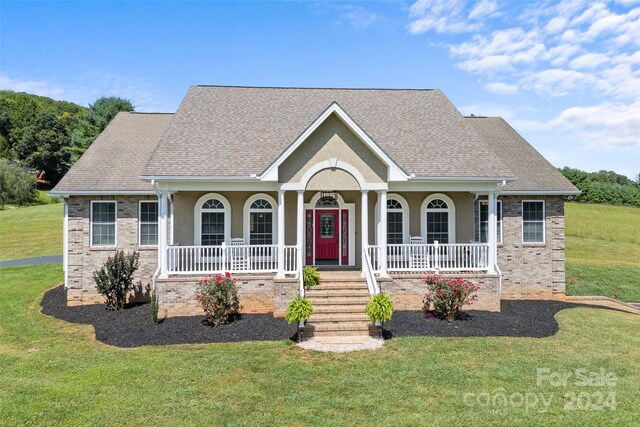 view of front facade with a front yard and covered porch