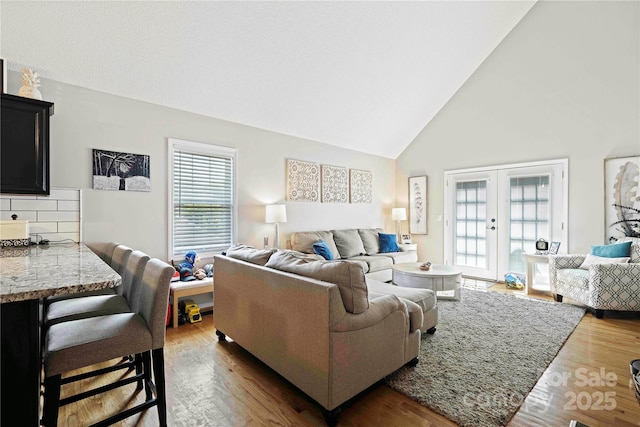 living room with french doors, dark hardwood / wood-style flooring, and high vaulted ceiling