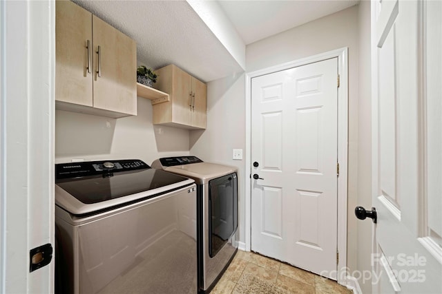 washroom featuring washer and clothes dryer and cabinets