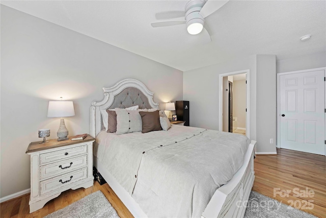 bedroom with ceiling fan, light wood-type flooring, and ensuite bathroom