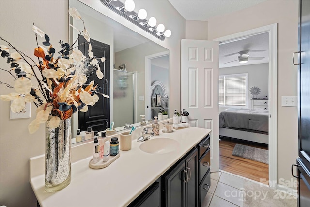 bathroom featuring vanity, tile patterned flooring, ceiling fan, walk in shower, and a textured ceiling