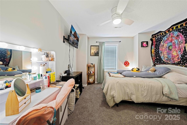 carpeted bedroom with ceiling fan and a textured ceiling