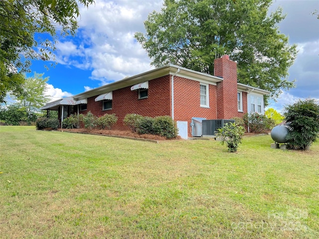 view of side of property featuring a lawn and cooling unit