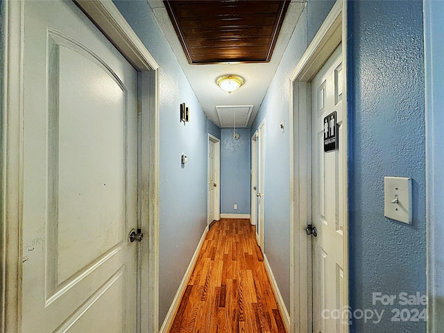 hallway with hardwood / wood-style flooring