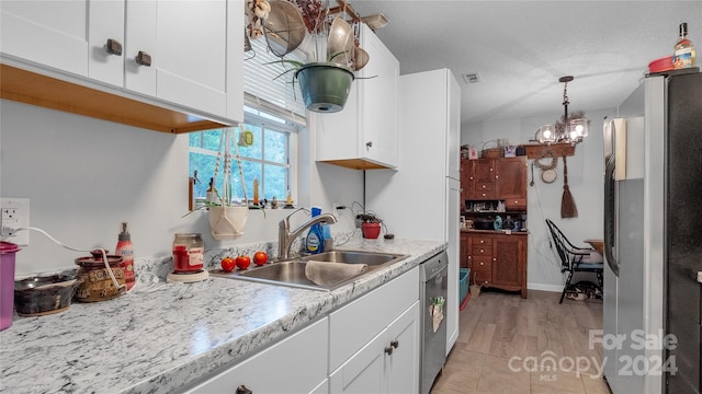 kitchen with white cabinetry, sink, stainless steel appliances, an inviting chandelier, and light wood-type flooring