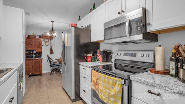 kitchen featuring white cabinetry, stainless steel appliances, a notable chandelier, pendant lighting, and light tile patterned floors