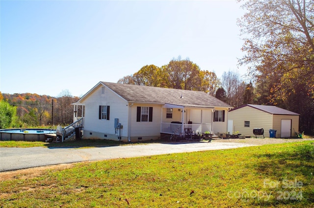 view of front of house with a front yard and an outbuilding