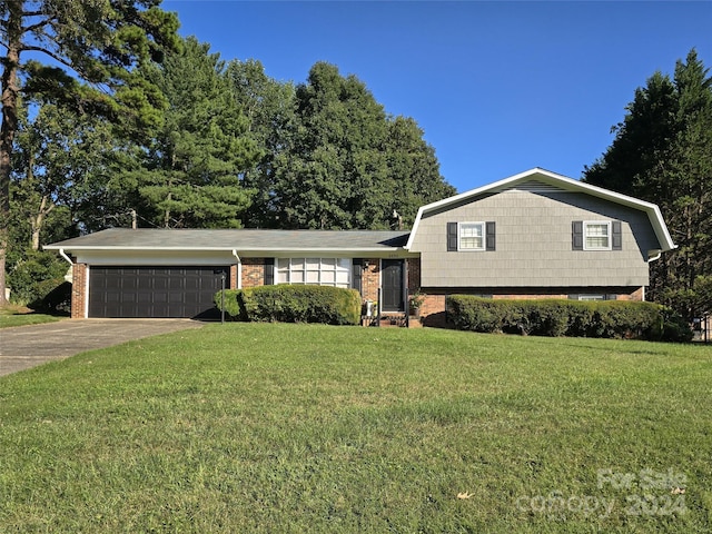 tri-level home with a garage and a front yard