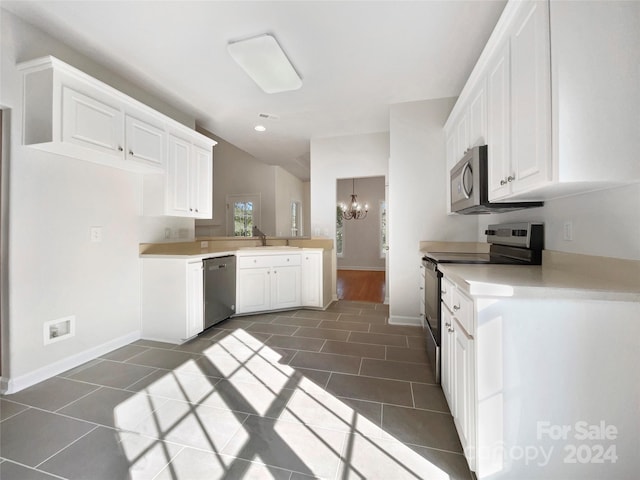 kitchen featuring appliances with stainless steel finishes, white cabinetry, and an inviting chandelier